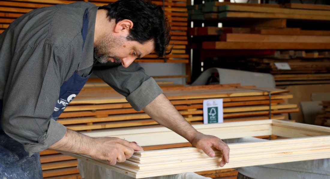 Un artigiano lavora un serramento in legno certificato